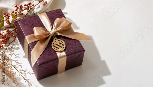 Elegant traditional Korean Chuseok holiday gift box with gold ribbon and corporate present packaging on a bright surface for festive celebration.