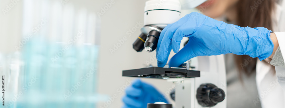 Naklejka premium researcher using microscope analyse cell in medical lab.
