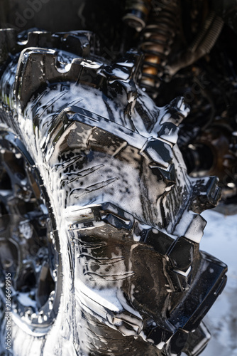 Close-up of vehicle wheel wash with soap foam