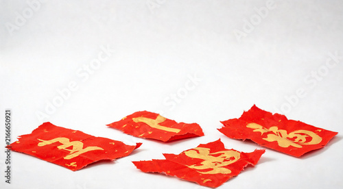 Torn red paper fragments with gold calligraphy details on white background