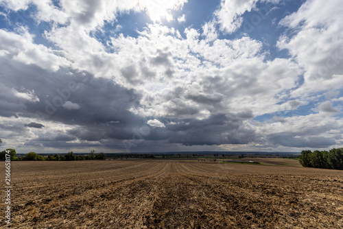 Landschaft  mit großen weisen Wolken und regen im Hintergrund