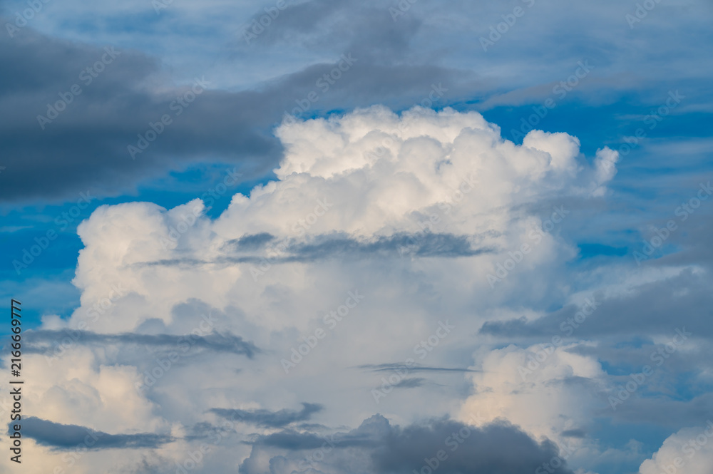 Fototapeta premium Dramatic white cumulus clouds and dark storm clouds floating across a vibrant blue sky, captured from Mount Shizitou in New Taipei City, Taiwan.