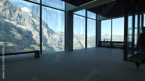 Silhouette of a man walking inside a panoramic building with stunning views of the eiger express station. Switzerland