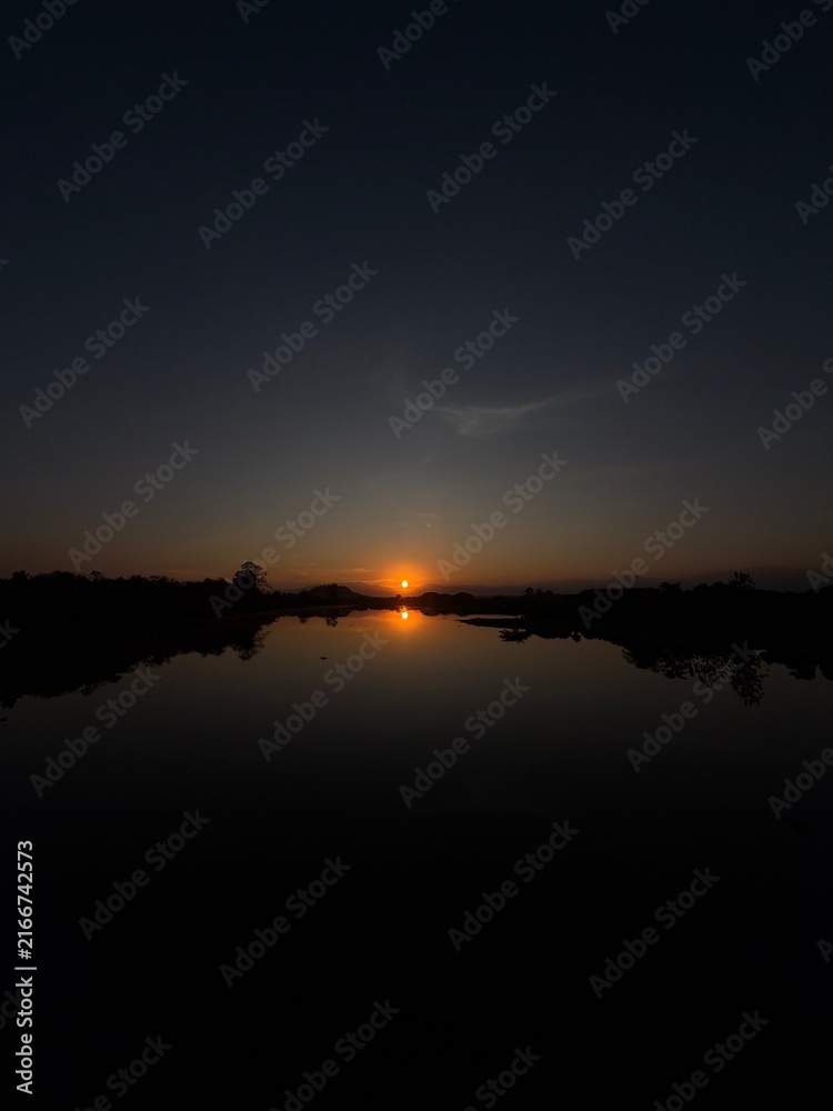 Obraz premium Golden Sunset Reflected in a Calm Lake
