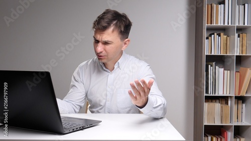 Quadro su tela frustrated man shrugging and gesturing, sitting at a desk and trying to understa