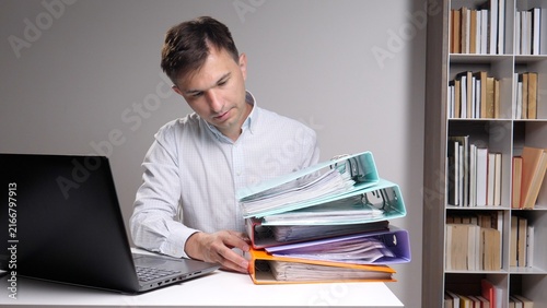 Cuadro en lienzo businessman concentrating on organizing a large stack of colorful ring binders f