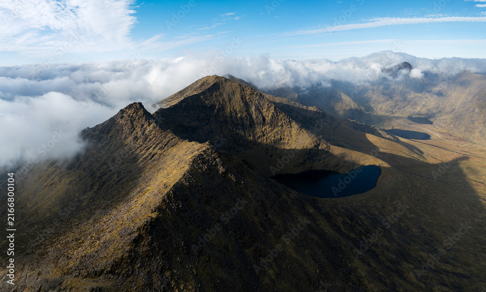 Obraz premium Panoramic aerial view of Big Gun peak, Lough Cummeenapeasta lake and distant Carrauntoohil in MacGillycuddy's Reeks, County Kerry, Ireland