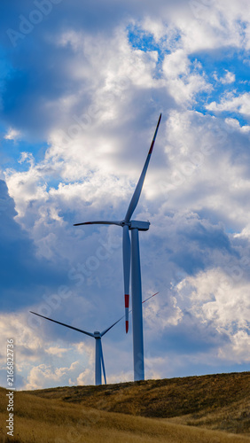 Multiple wind turbines across a mountain landscape, representing renewable energy, clean technology, sustainable development and the transition toward a low-carbon future.