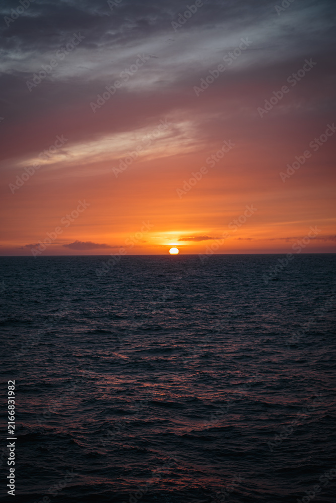 Fototapeta premium Sunset Viewed from a Cruise Ship Sailing Across the North Atlantic with Warm Reflections Along the Deck, August 2026