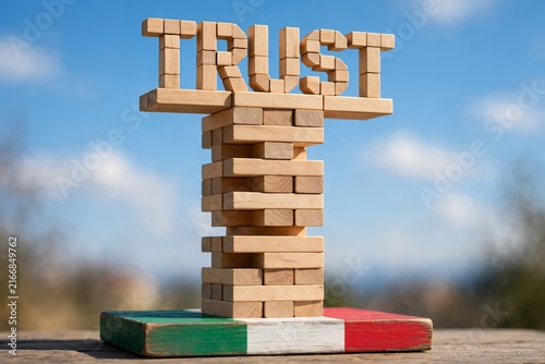 Wooden block tower with TRUST text on Italian flag base