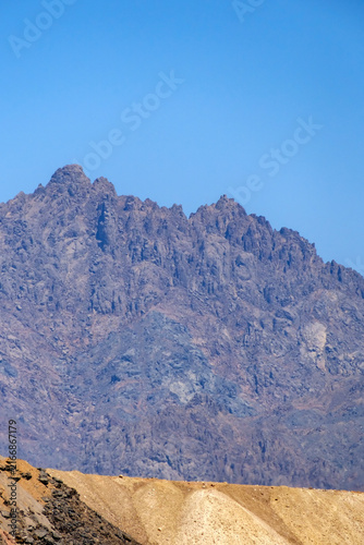 Cuadro en lienzo Rugged mountain peaks under a clear blue sky in an arid desert landscape