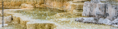 Obraz na plátně Raindrops causing bubbles in water colorful thermophiles in calcite scalloped lo
