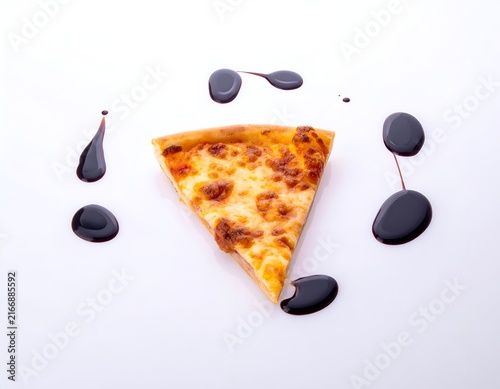Pizza slice with decorative balsamic vinegar drops.