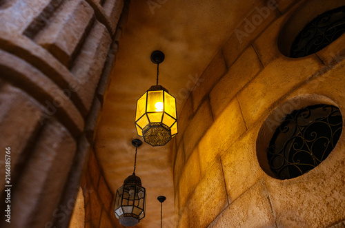 Cuadro en lienzo Warm glowing traditional lanterns hanging from stone archway ceiling