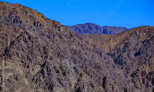 Canvas Print Rugged desert mountains under a clear blue sky showcasing geological formations