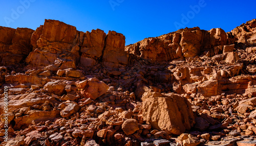 Konstfotografi Rocky canyon terrain with rugged sandstone boulders and bright blue sky