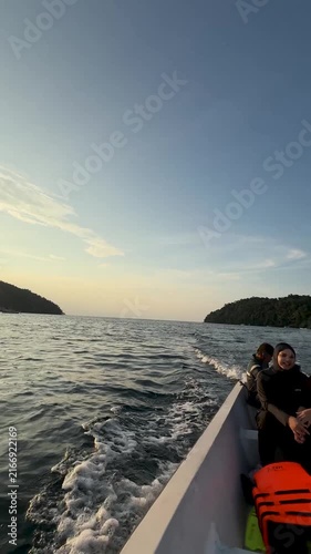 Carefree couple relaxing on a boat at sunset on the sea, a romantic vacation and travel concept. Weh Island, Sabang, Indonesia