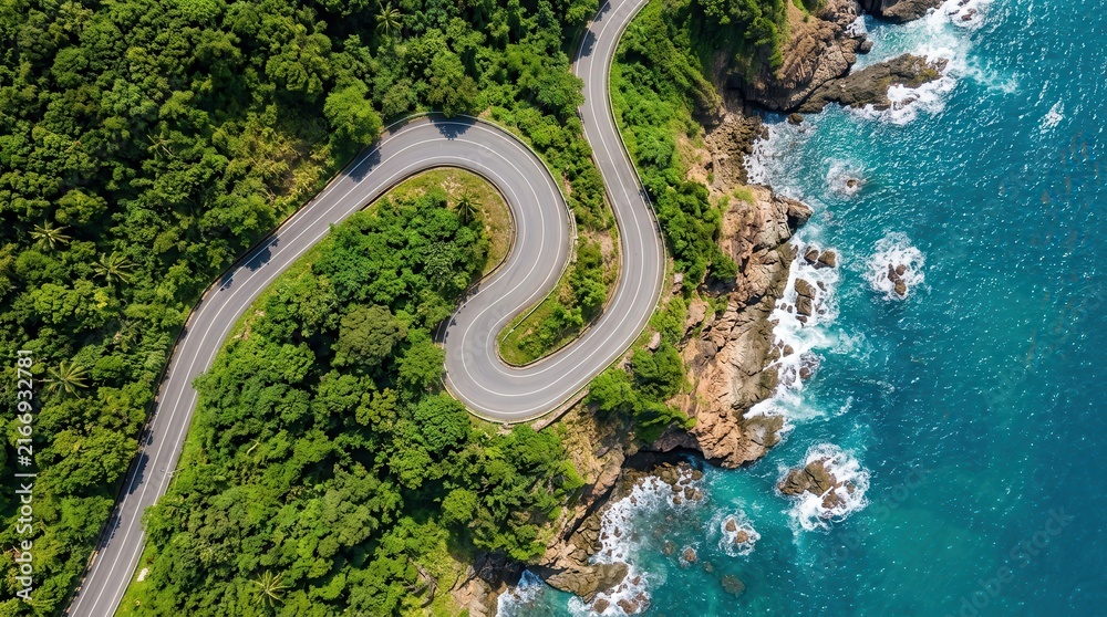 Obraz premium High angle shot of a scenic asphalt highway curving along a rocky ocean shore.