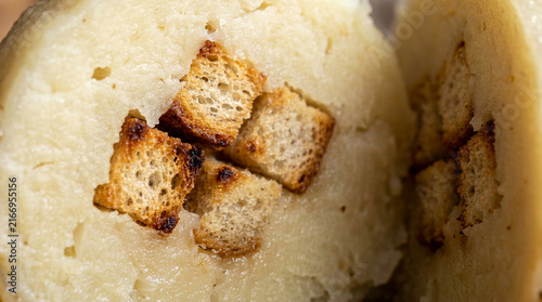 Creamy potato soup served inside a hollowed bread bowl garnished with crispy toasted croutons