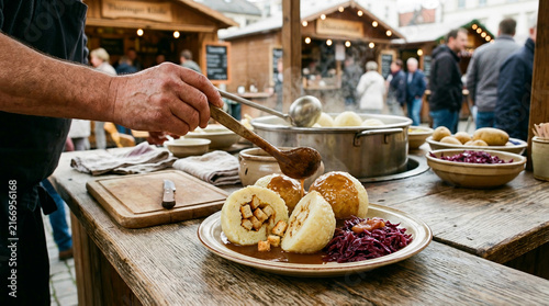 Chef serving traditional German potato dumplings with red cabbage and gravy at an outdoor food stall in a market square