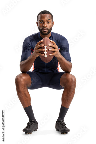 Athletic man holding american football in compression gear isolated on a transparent background