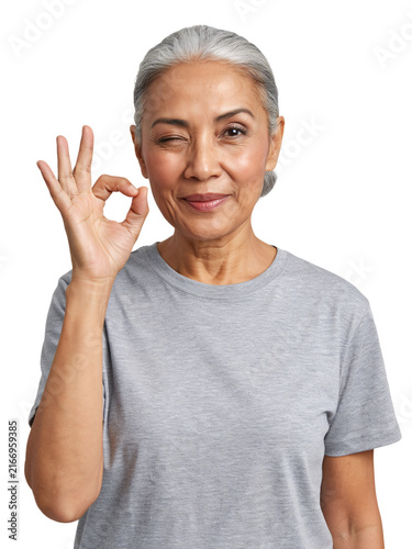 Asian woman winking and making an ok gesture isolated on a transparent background