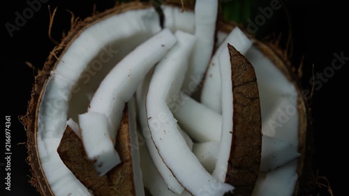 Fresh coconut slices and white flesh in a coconut shell, showing tropical food texture and natural ingredients