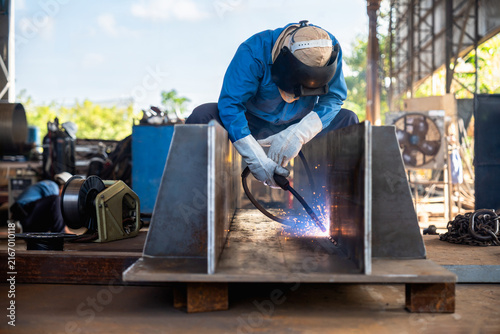 Industrial welder welding fabricated construction in factory, Welding process by Flux Core Welding, FCAW