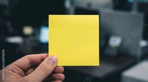 Blank yellow sticky note held in hand isolated on transparent background. Office memo concept.