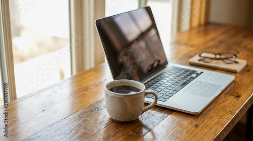 Cup of Coffee and Laptop on Modern Work Desk