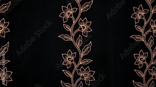 Gold floral embroidery on black background.