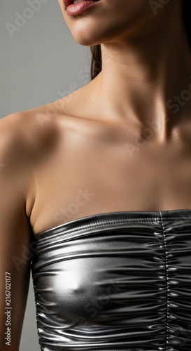 woman wearing a fashionable shiny metallic silver strapless top in studio