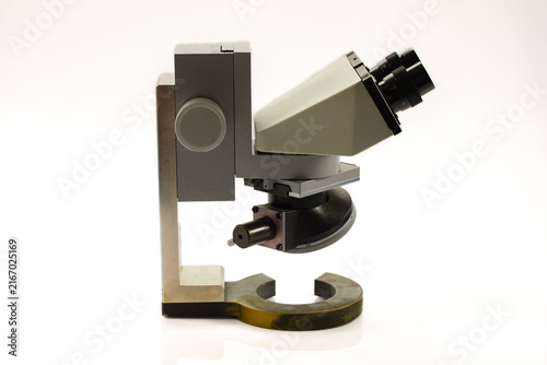 Vintage binocular microscope with adjustable optical head, precision focusing mechanism and sturdy metal stand, isolated against a clean white background.