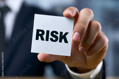 Business Hand Holding Risk Card in Modern Office