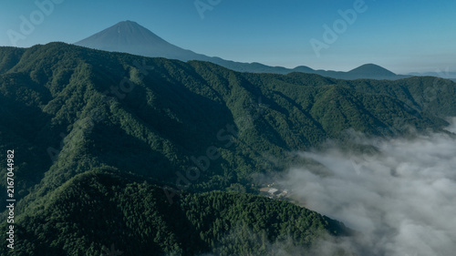 Naklejka 雲が流れる山岳地帯と遠くに望む富士山