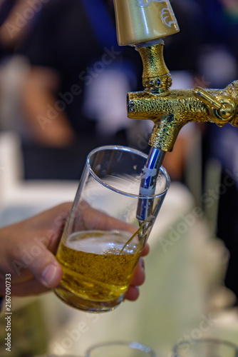 Pouring Fresh Draft Beer into Glass from Golden Tap