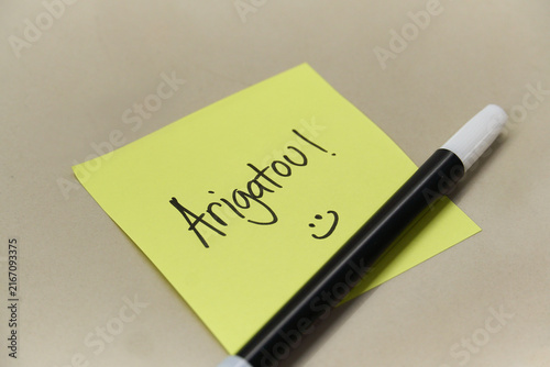 Obraz na plátně Handwritten Arigatou Thank You text in Japanese on yellow sticky note with marke