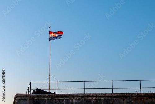 Obraz na plátne Croatian Flag Flying Above Historic Stone Rooftop