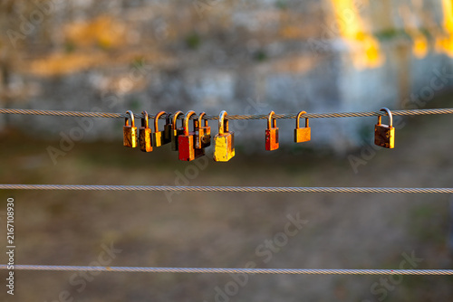 Fotografía Colorful Love Padlocks Hanging on Steel Cable at Sunset