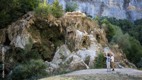 Bild auf Leinwand touriste devant la cascade de tufs de Baume-les-Messieurs dans le Jura