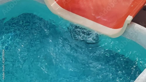 Blue Pool Water Moving Beside Red Slide