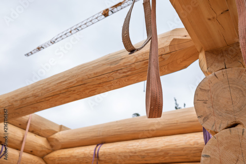 The construction site of a wooden house. Traditional log cabin built from wood logs on sunny summer day. Cottage house design