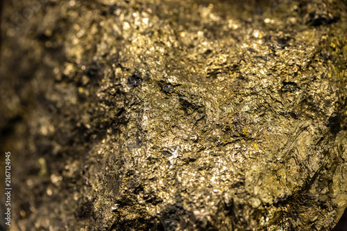 Fotografie Close-Up Shiny Gold Mineral Rock Texture Background With Metallic Sparkle And Na