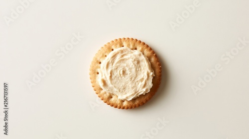 Crunchy biscuits topped with spreadable cheese on plain white backdrop