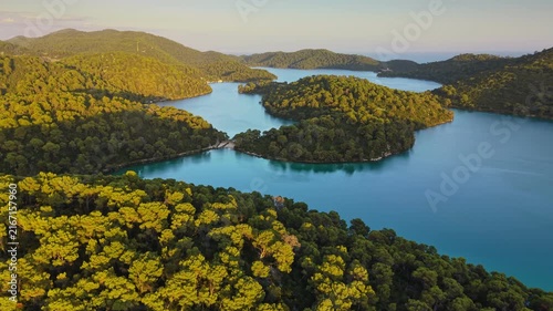 Golden sunset light covers the dense green forests of Mljet national park in Croatia. Dense woods meet peaceful inland sea lakes in this Croatian paradise. Mljet island, Croatia