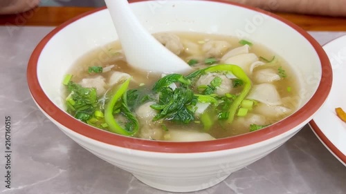 Close Up of Chinese Wontons on Restaurant Table – Traditional Dumpling Soup with Green Onions