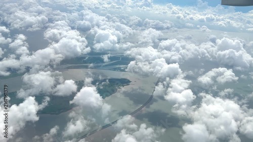 View from Airplane Window Looking Down at Clouds – Aerial Perspective of Fluffy White Clouds Over Blue Sky