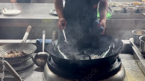 Chinese Street Food – Stir Frying Noodles in Large Wok Over Open Flame at Outdoor Market Stall