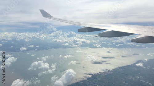 View from Airplane Window Looking Down at Clouds – Aerial Perspective of Fluffy White Clouds Over Blue Sky