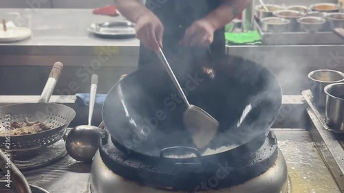 Chinese Street Food – Stir Frying Noodles in Large Wok Over Open Flame at Outdoor Market Stall
